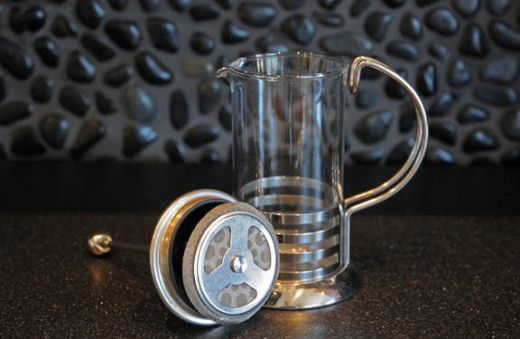 A French Press disassembled--pot and plunger.