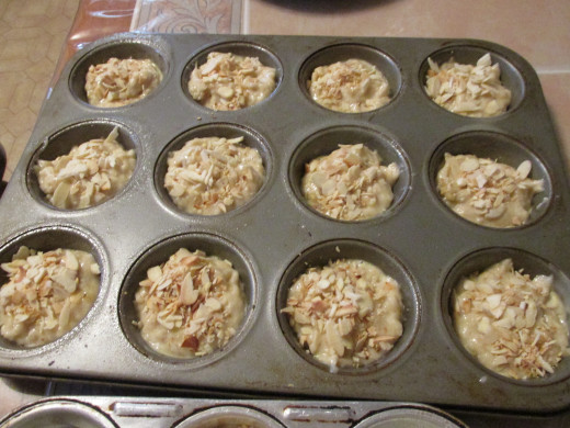Muffins before baked showing almonds on top