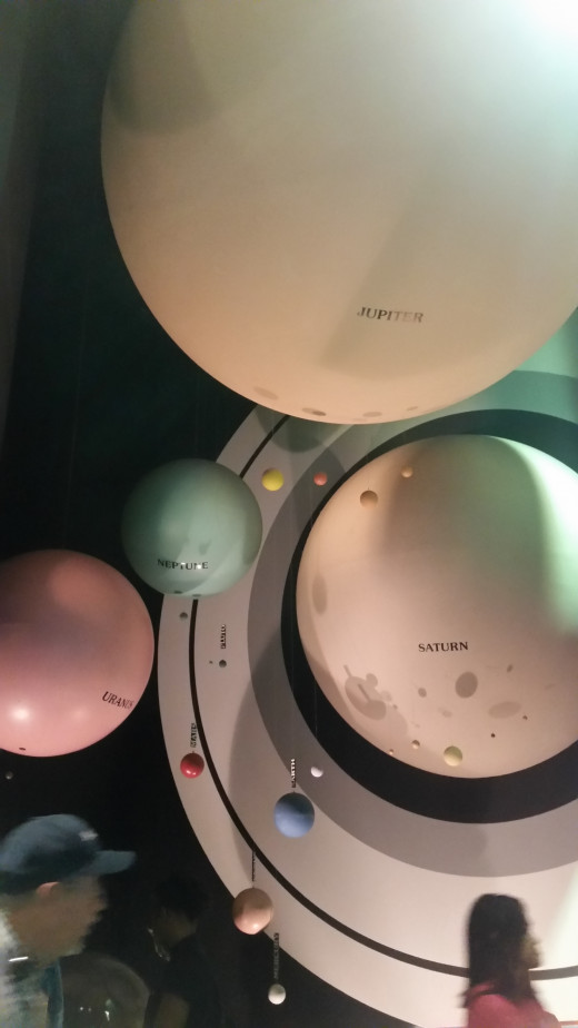 These models show the difference in size of the planets. Saturn is the really big one with rings, and we are one of the smaller green and blue ones. Can you spot Earth? 