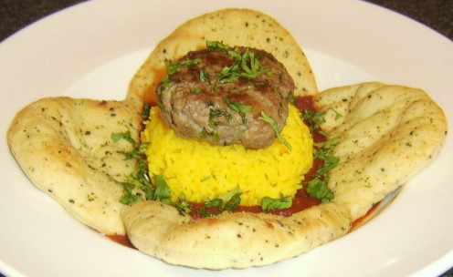 Succulent lamb burger served Indian style with spicy rice, bhuna sauce and naan bread