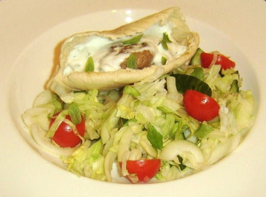 Spicy lamb burger in pitta bread with salad and sauce