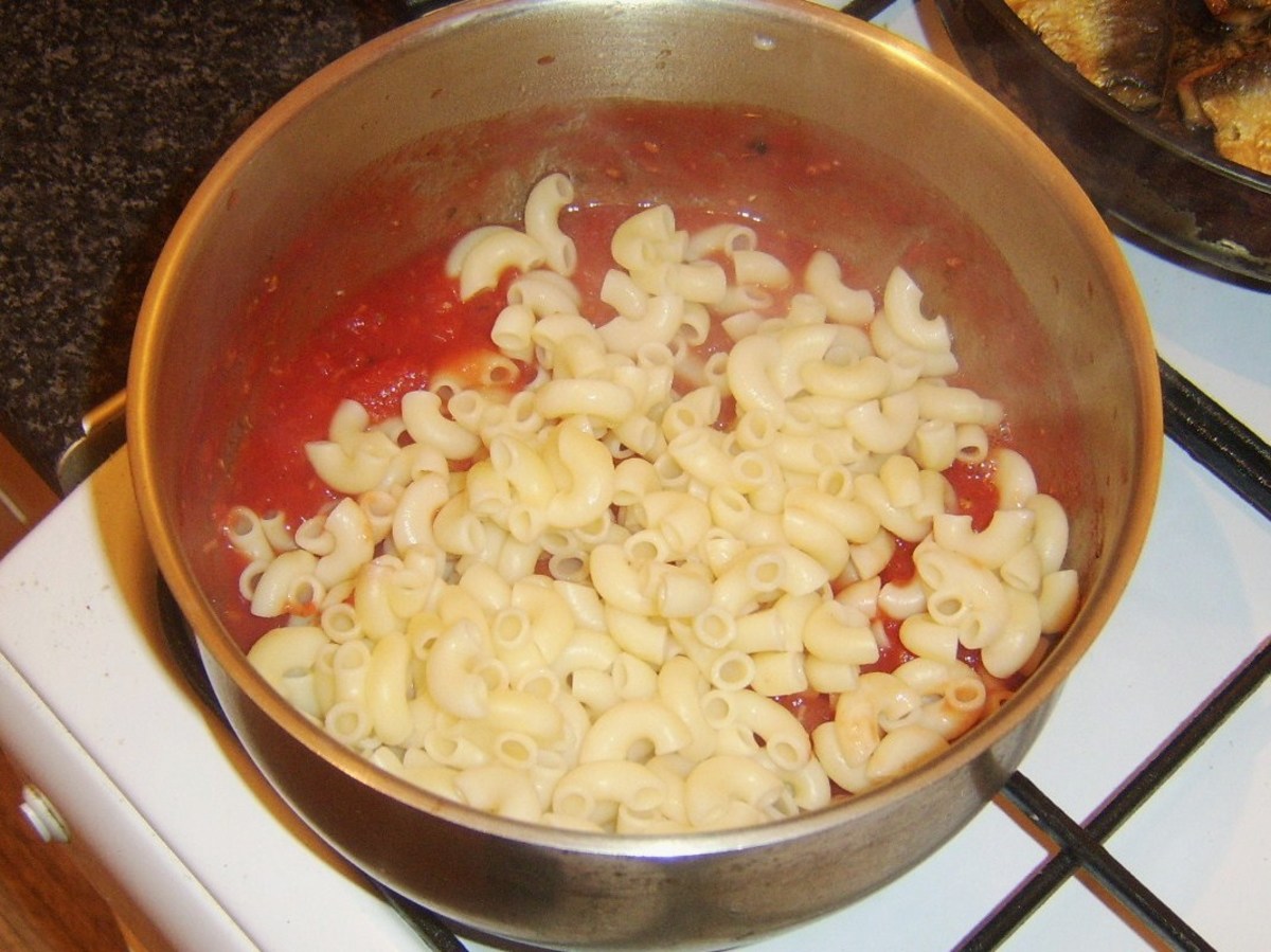 Cooked macaroni is stirred in to tomato sauce