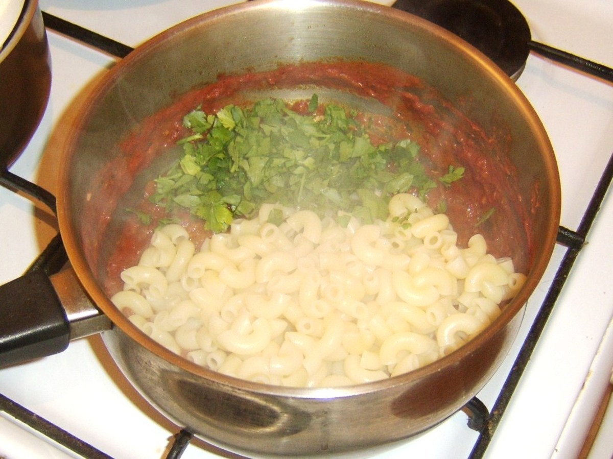 Cooked macaroni and pasta are added to spicy beef and tomato stew