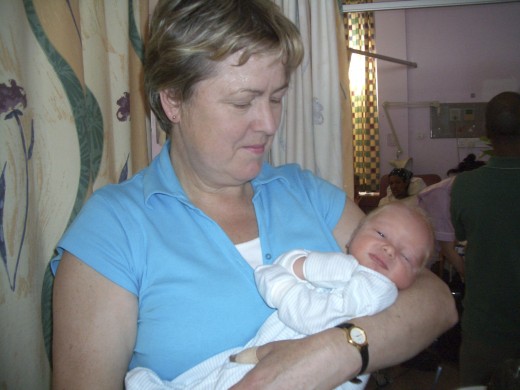 Newborn baby (12 hours old) with his proud grandmother in the same ward