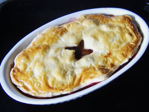 Apple, blackberry and cinnamon pie is taken from the oven