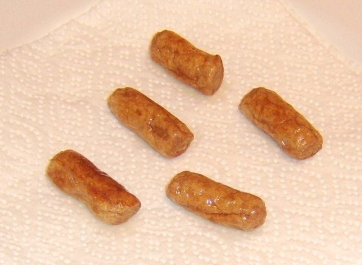 Fried sausages are drained on kitchen paper