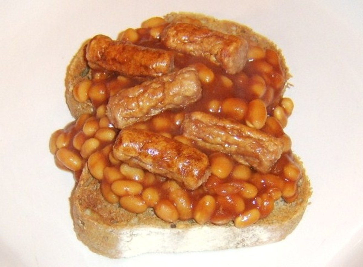 Mini sausages are laid on beans on toast