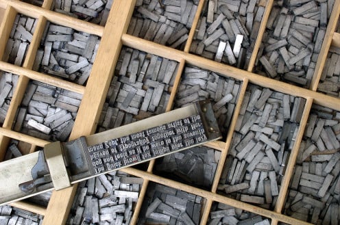 Metal movable type and a composing stick