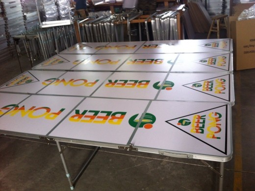 A beer pong table with orange, yellow and green writing