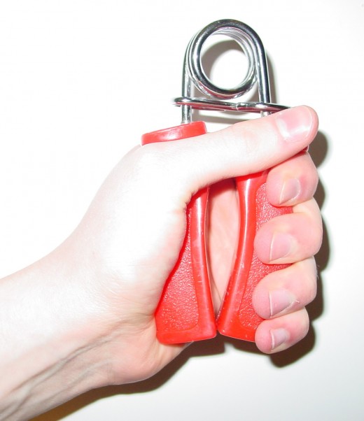 A person closing a simple, fixed spring gripper.  Companies will sometimes color code their fixed grippers to more easily illustrate their resistance levels.