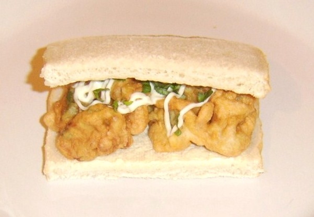 Deep fried bell pepper fritters on a simple sandwich with mayo and basil
