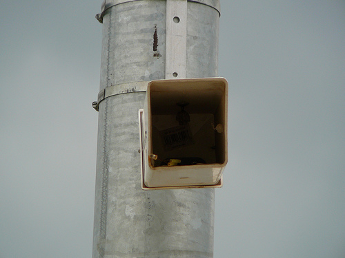 Fake Security Camera by John of Austin via Flickr.  Notice the wasps nest, UPC sticker and broken LED seen inside this fake surveillance camera