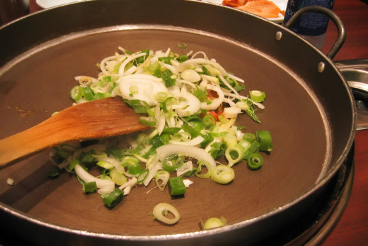 Frying the spring onions with the ginger and garlic