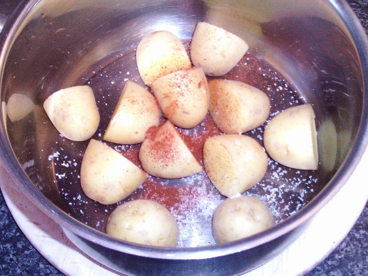 Salt and paprika are added to halved babay potatoes