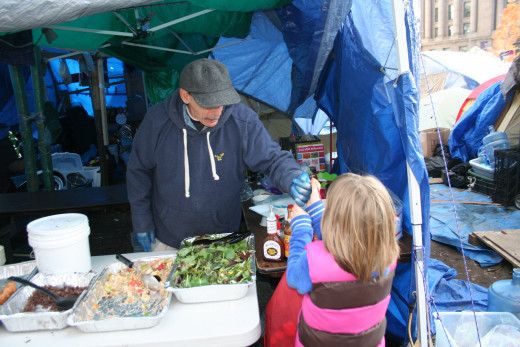 My daughter bringing a donation to the food tent at Occupy Boston.