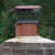 Concrete crown of masonry chimney encasing fireclay flue.