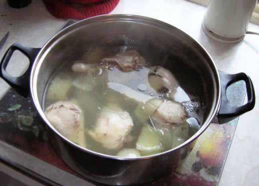 basic broth before being strained, removing  chicken legs   and  adding vegetables