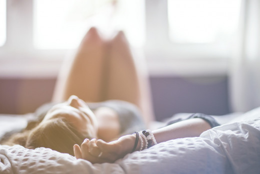 A woman resting on her bed.