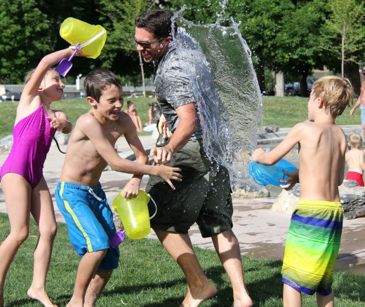 A father and his kids enjoying the sunshine in a park.