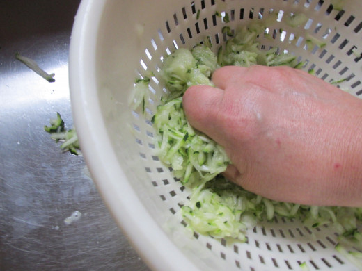 Squeezing out the juices of both zucchini and onion.