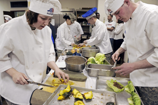 Students preparing meals in a culinary school kitchen. 