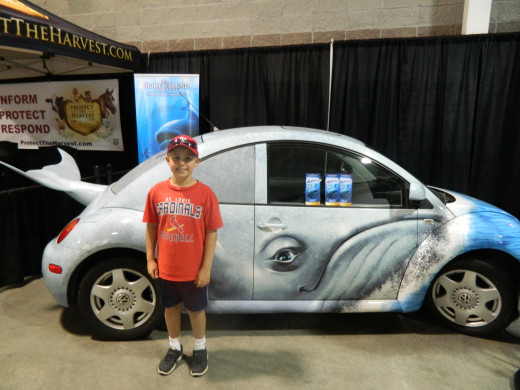 Caleb in front of a Beetle Bug dressed up to advertise Jonah and the Whale, a local show currently going on in Branson.
