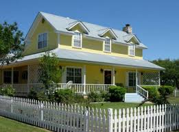 A yellow house with a picket fence