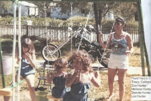 This is my dad's harley in the background. My mom is in white shorts. My two sisters and I are on the swing set. 