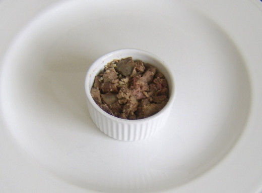 Chicken livers are loosely packed in ramekin