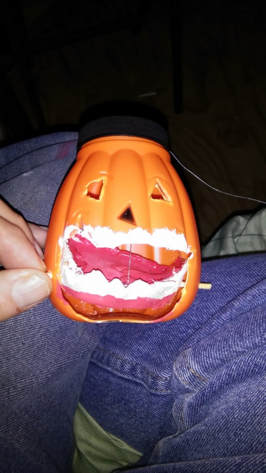 I use a pumpkin drink bottle from the dollar store. I cut out the mouth area to fit the mouth into. It is afixed to a pivot made from an orange stick.