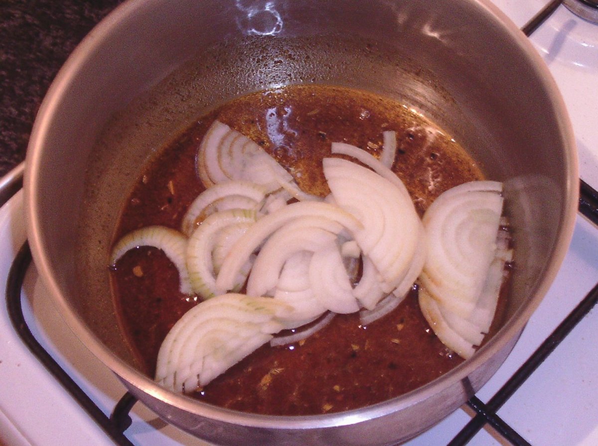 Sliced onion is added to fried spices