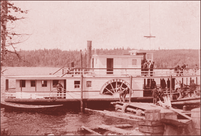 A riverboat pulling lumber on the St. Johns River which forms the border between Maine and New Brunswick in the tip of Northern Maine.