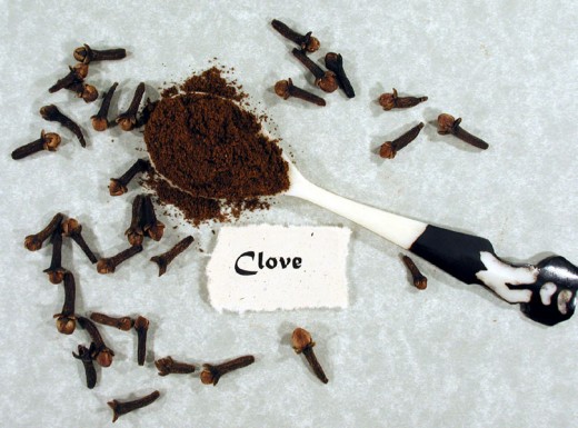 Ground cloves surrounded by dried clove buds.  