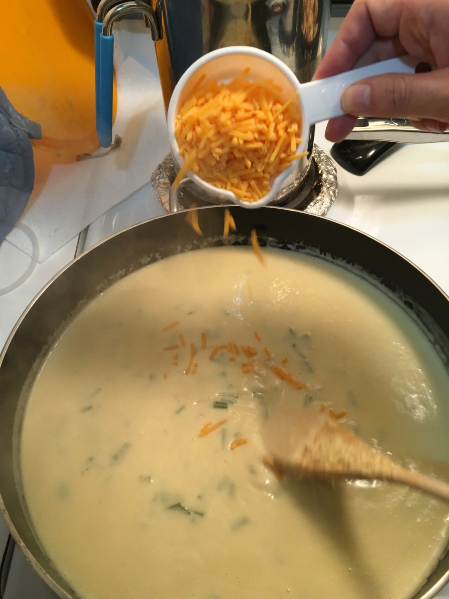 Once you start to add the sharp cheddar the sauce takes on a yellow color.