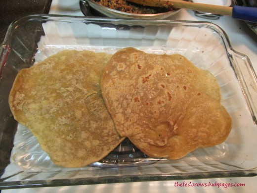 First, lightly grease and add two tortillas. 