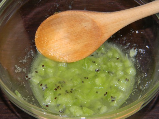 Smash the fruit while mixing all the ingredients together.  Some people like to mash the Kiwi in a food processor or blender before adding it to the sugar and oil.