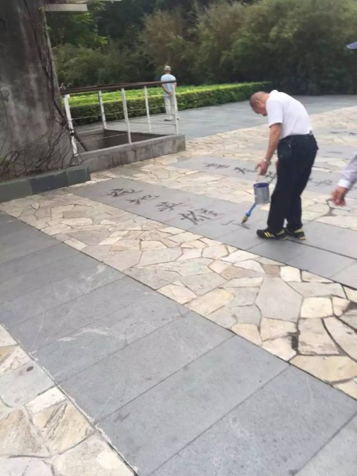 Painting Chinese characters with a long-handled water brush is a skilful art