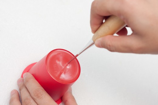 Poke 3 holes in the bottom of your yogurt cup witht the awl.