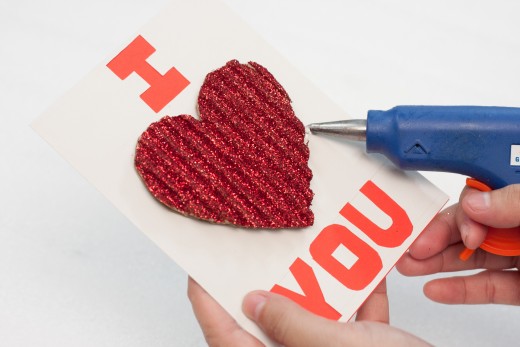 Place the glittery heart in the center of your card.  When you like the way it looks use your hot glue gun to glue the heart in that spot.