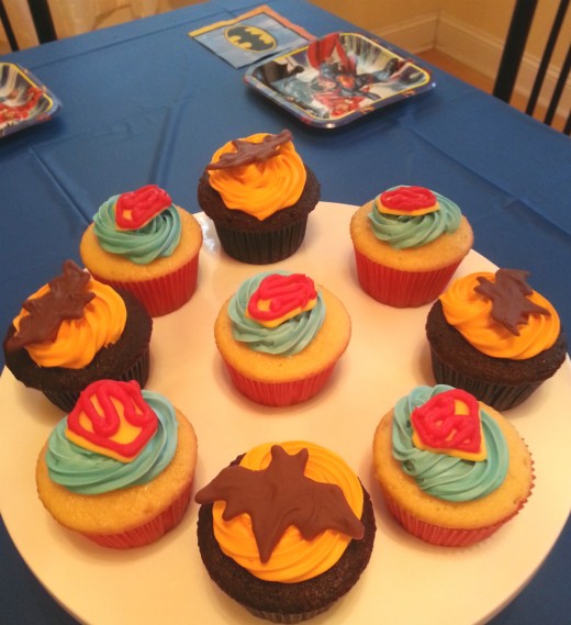 The table can be decorated with a dark blue tablecloth, Batman napkins, Justice League plates and a cupcake centerpiece.