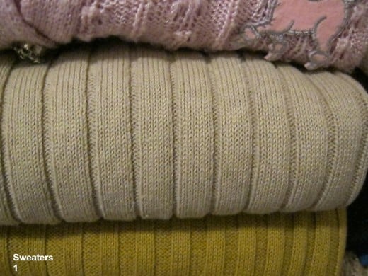 Vintage sweaters folded neatly on a closet shelf.