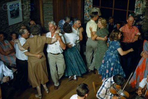  Couples swirl  around a fiddler  at a square dance in 1952.