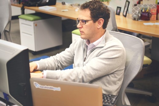 A man staring at his computer while sitting down. 