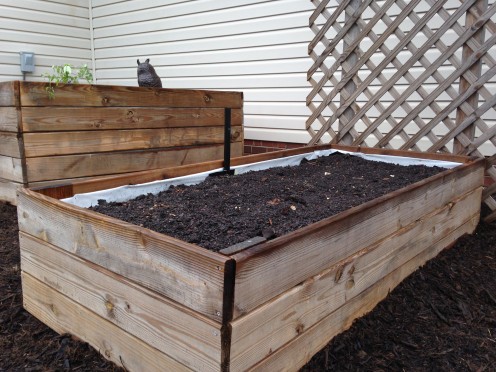 Soil added on top of finished system with a watering pipe poking out the top to feed the reservoir at the bottom.