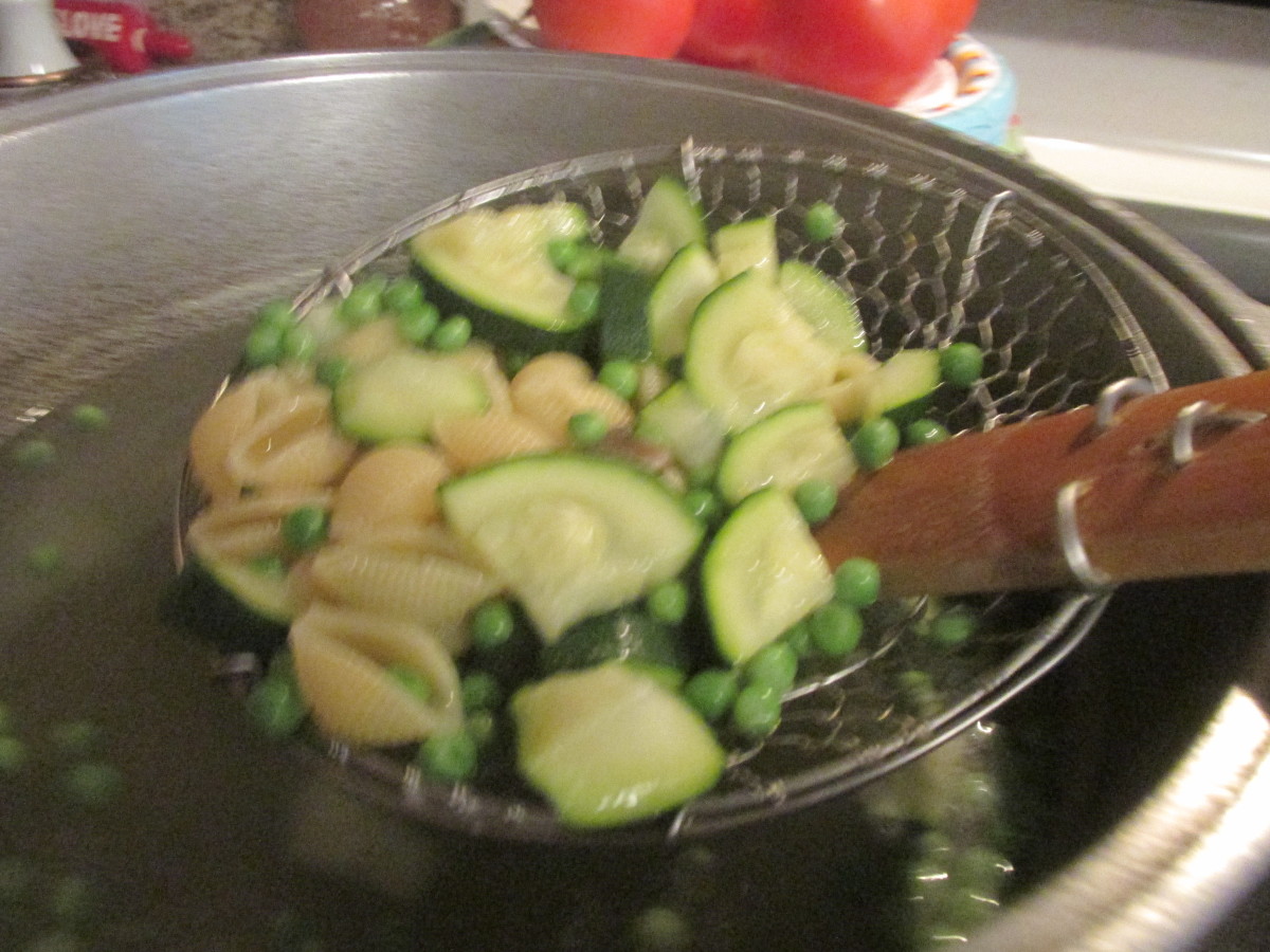 Scooping out the vegetables and pasta to put in the frying pan.
