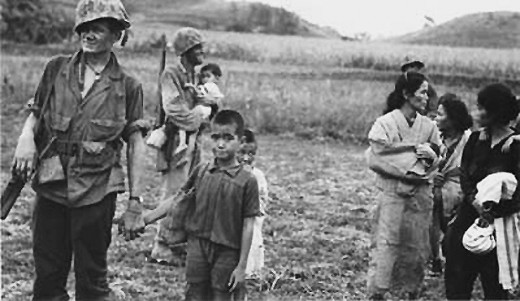 Marines escorting civilians to safety. More than 20,000 non-combatants died during the battle.