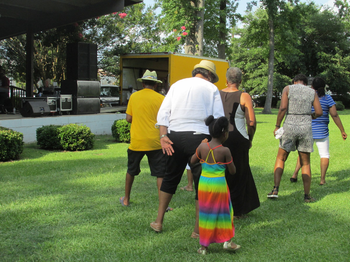 Line dancing was performed in the park during the cookout.