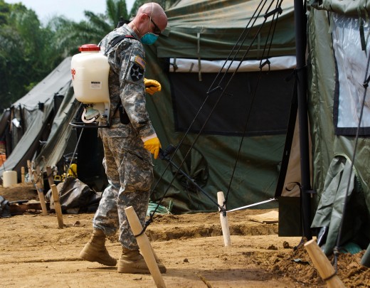 Preventative medicine soldier sprays insecticide around living quarters in Gbediah, Liberia, Dec. 15, 2014. Taken during Operation United Assistance, the joint effort to combat the devastating Ebola outbreak.