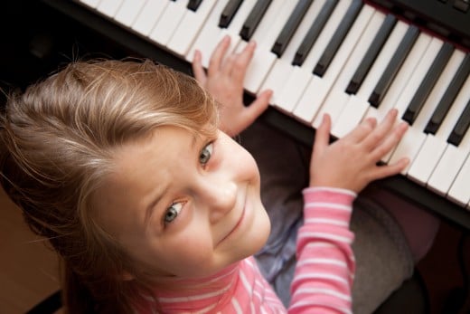 A young girl playing on a keyboard