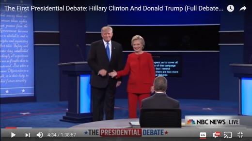 The handshake has ended, and both candidates are square to the audience.  HRC's right arm begins to shift from the handshake toward the audience.